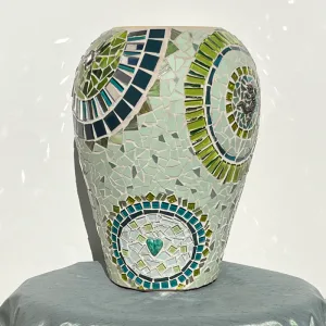 Handcrafted circular mosaic patterns in layered greens and mirror tiles reflect light beautifully, while whimsical geckos bring playful charm.